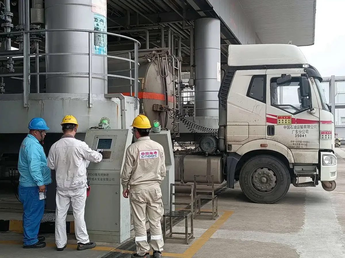 An operator swipes the driver's ID card at the batch controller to verify loading information. Photo: He Xiaozhong